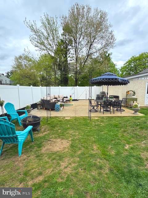 view of yard featuring an outdoor living space with a fire pit, a patio area, and a fenced backyard