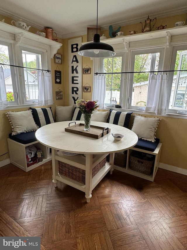 dining room featuring baseboards, breakfast area, and ornamental molding