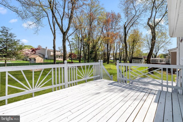 wooden deck with a residential view and a lawn