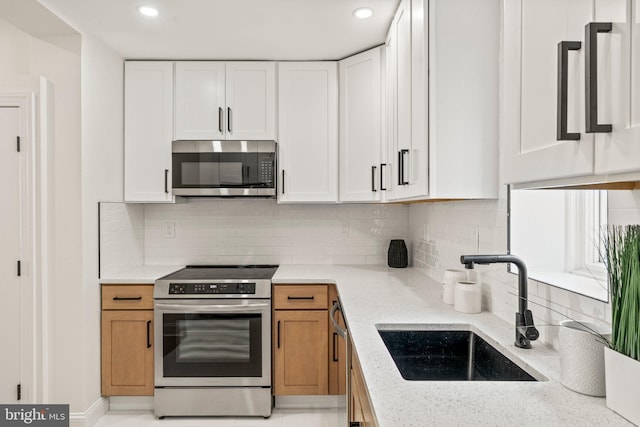 1102 Mercy St, Philadelphia, PA 19148 - kitchen with light stone counters, stainless steel appliances, white cabinetry, and a sink