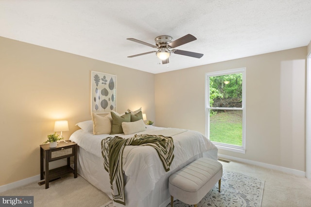 bedroom with light carpet, baseboards, and a ceiling fan