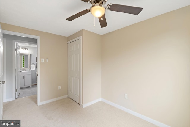 unfurnished bedroom with carpet, baseboards, a ceiling fan, and a closet