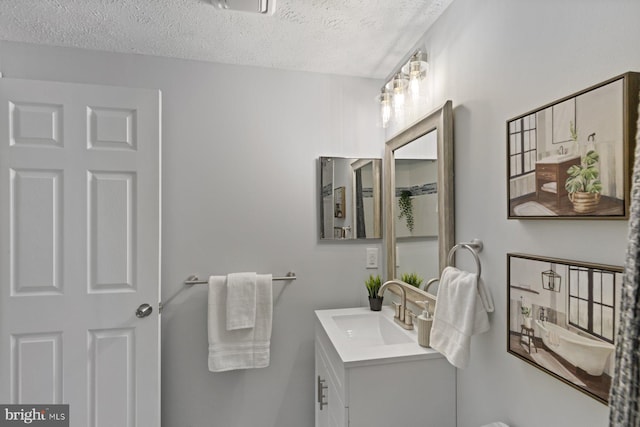 bathroom featuring a textured ceiling and vanity