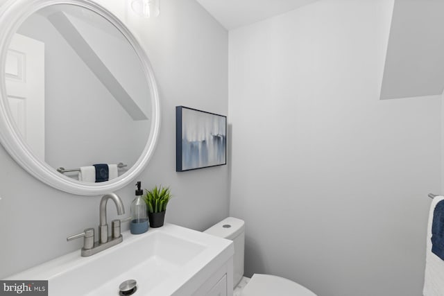 half bathroom with toilet and vanity