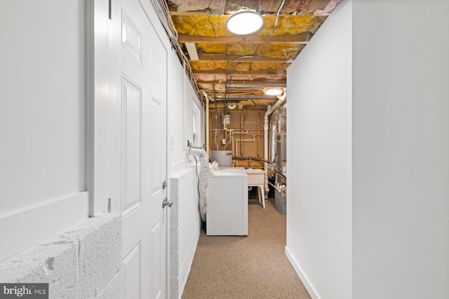 unfinished below grade area with washer / dryer, carpet floors, and a sink
