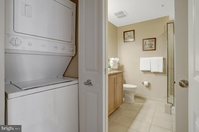 888 N Quincy St Unit 407, Arlington, VA 22203 - bathroom with stacked washer / drying machine, vanity, a stall shower, toilet, and tile patterned floors