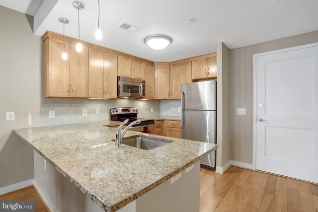 888 N Quincy St Unit 407, Arlington, VA 22203 - kitchen featuring appliances with stainless steel finishes, a sink, baseboards, a peninsula, and light wood-style floors