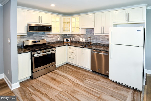 6137 Leesburg Pike Unit 101, Falls Church, VA 22041 - kitchen featuring stainless steel appliances, a sink, tasteful backsplash, baseboards, and dark stone counters