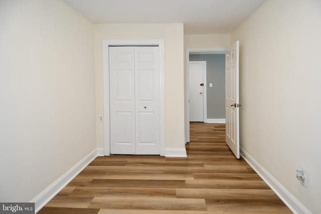6137 Leesburg Pike Unit 101, Falls Church, VA 22041 - unfurnished bedroom featuring light wood-type flooring, baseboards, and a closet