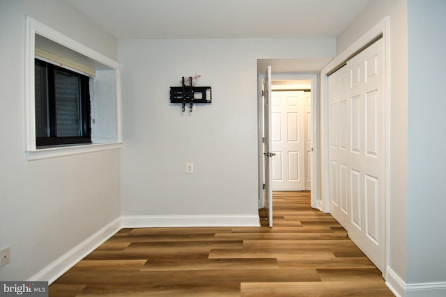 6137 Leesburg Pike Unit 101, Falls Church, VA 22041 - unfurnished bedroom with baseboards, wood finished floors, and a closet