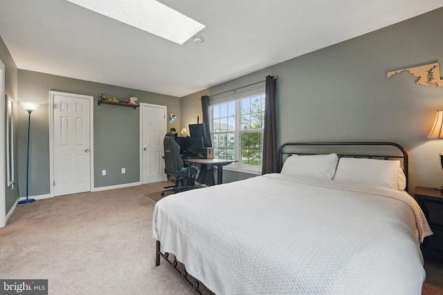bedroom with a skylight, baseboards, and carpet floors