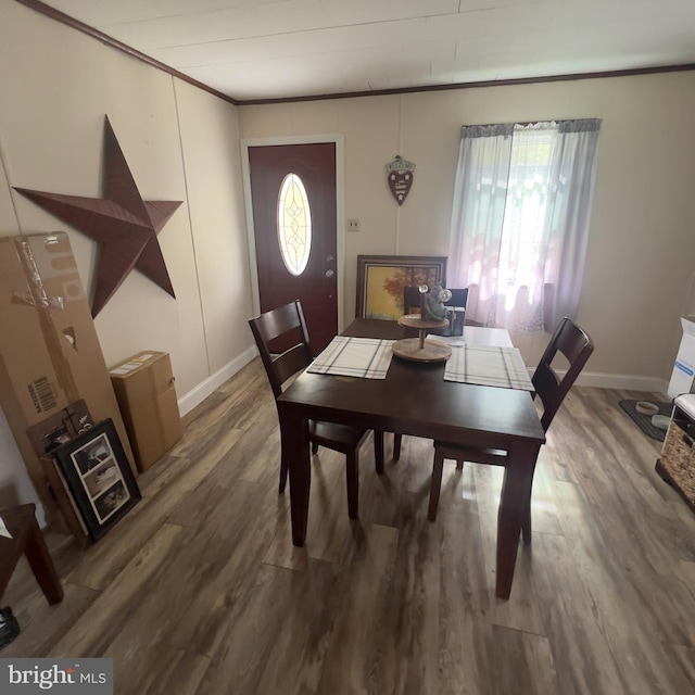 dining area featuring baseboards, ornamental molding, and wood finished floors