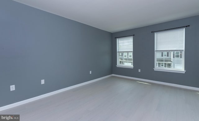 unfurnished room featuring light wood finished floors and baseboards