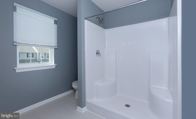 full bath with toilet, baseboards, and walk in shower