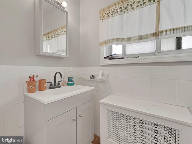 bathroom with tile walls, tasteful backsplash, radiator heating unit, and vanity