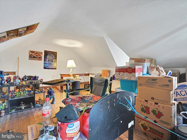 game room featuring wood finished floors, a textured ceiling, and lofted ceiling