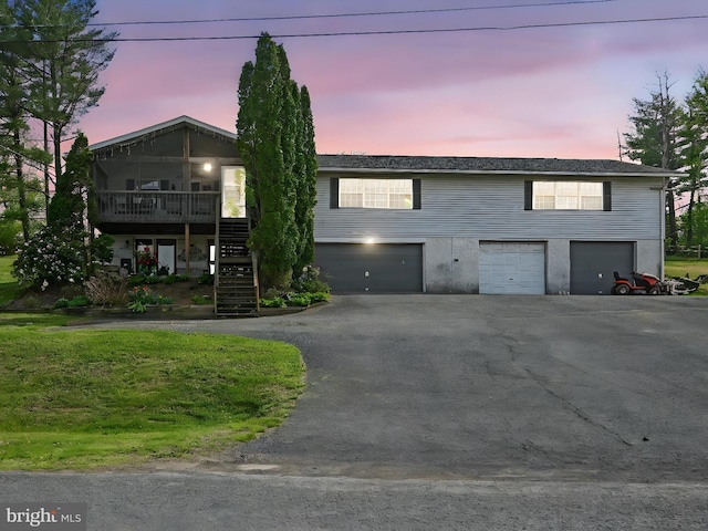 view of front of house featuring stairway, a garage, and aphalt driveway