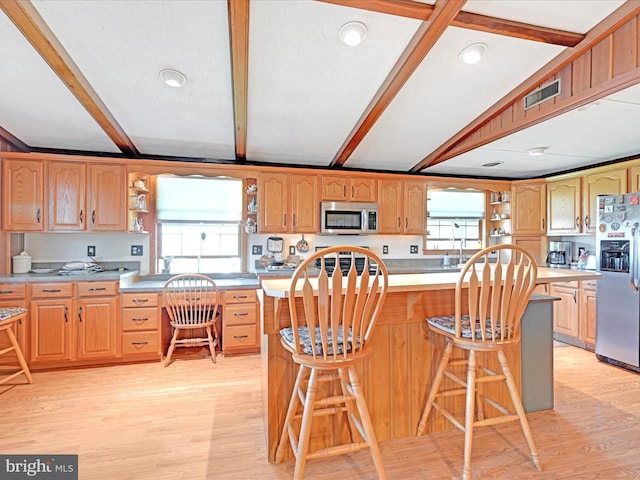 kitchen featuring light wood-style floors, open shelves, stainless steel appliances, and beam ceiling