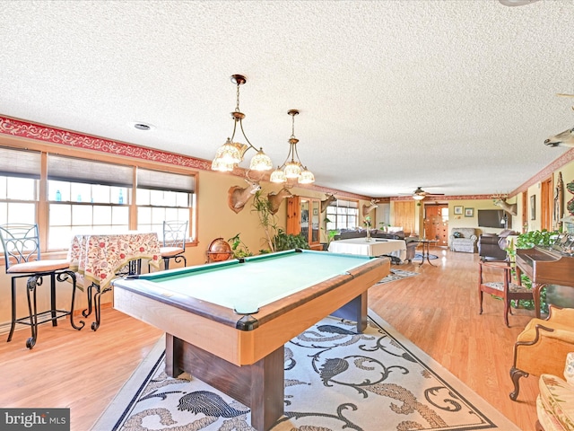 game room with pool table, a textured ceiling, ceiling fan, and light wood-style flooring