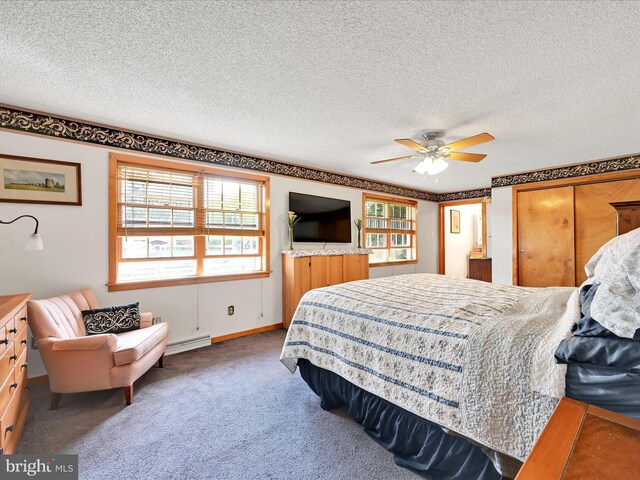 bedroom with a ceiling fan, carpet flooring, a baseboard heating unit, and a textured ceiling