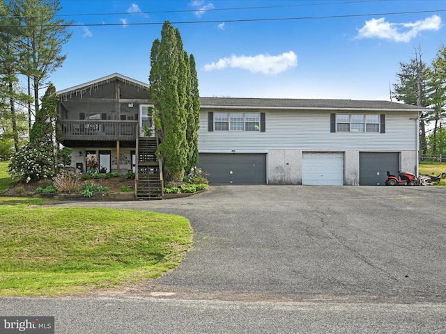 view of front of home with a deck, driveway, stairs, and a garage