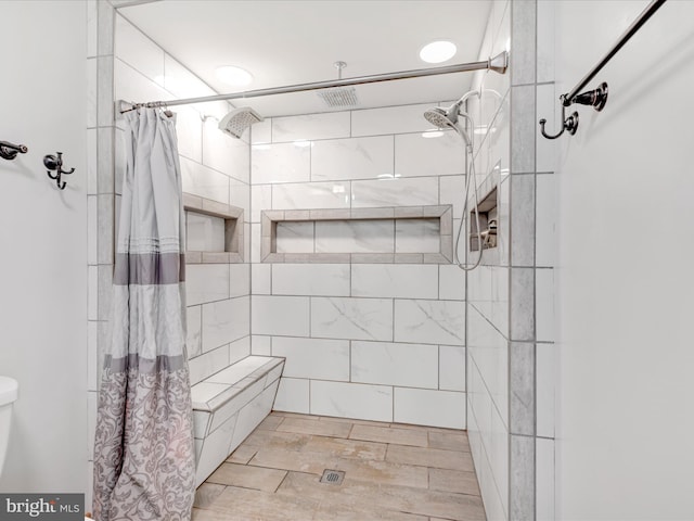 bathroom featuring toilet, visible vents, and a tile shower