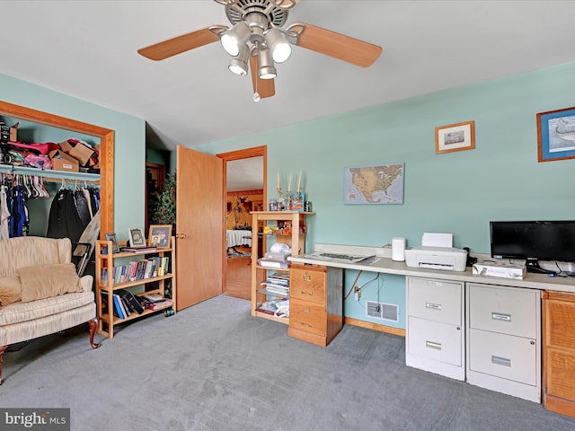 carpeted office with a ceiling fan and visible vents