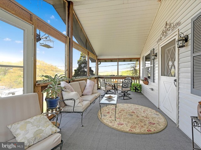 sunroom / solarium featuring plenty of natural light and an outdoor hangout area