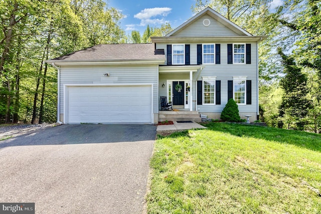view of front facade featuring a front lawn, aphalt driveway, and a garage