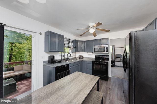 kitchen with dark wood finished floors, a healthy amount of sunlight, ceiling fan, and black appliances
