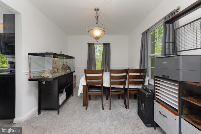 dining area with light carpet, baseboards, and plenty of natural light