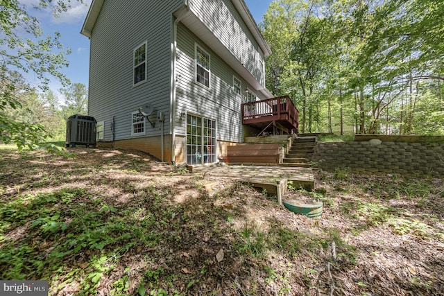 view of side of home featuring cooling unit, a wooden deck, and stairway