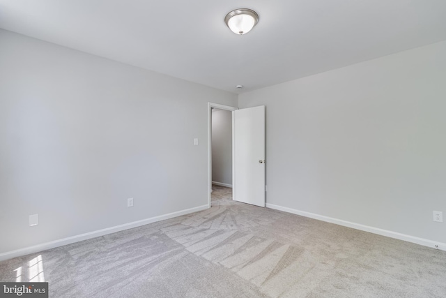spare room featuring baseboards and carpet