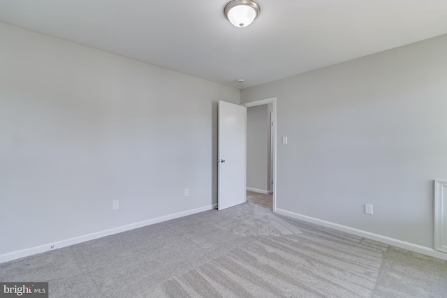carpeted spare room featuring baseboards