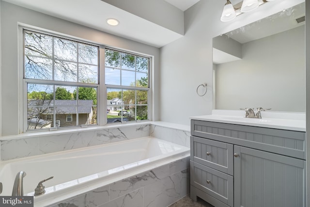 bathroom featuring visible vents, vanity, and a bath
