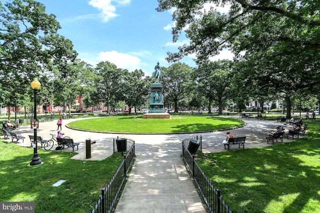 surrounding community with fence and a yard