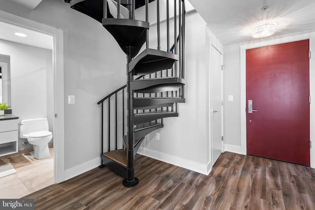 entrance foyer featuring stairway, baseboards, and wood finished floors