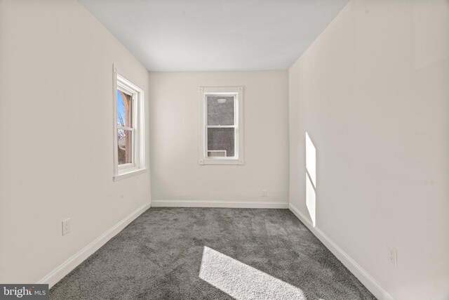 unfurnished room featuring baseboards and carpet