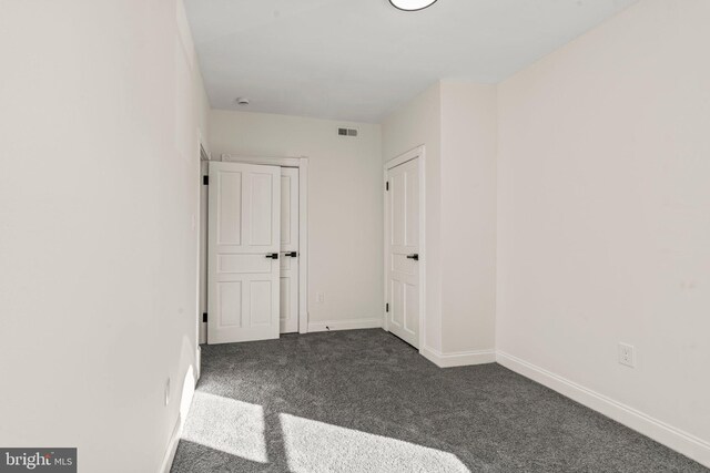 empty room with visible vents, carpet flooring, and baseboards