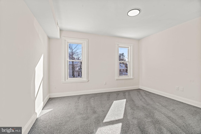 unfurnished room featuring baseboards, a healthy amount of sunlight, and carpet