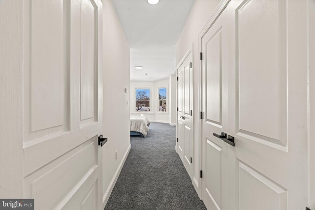hall featuring baseboards, dark colored carpet, and recessed lighting