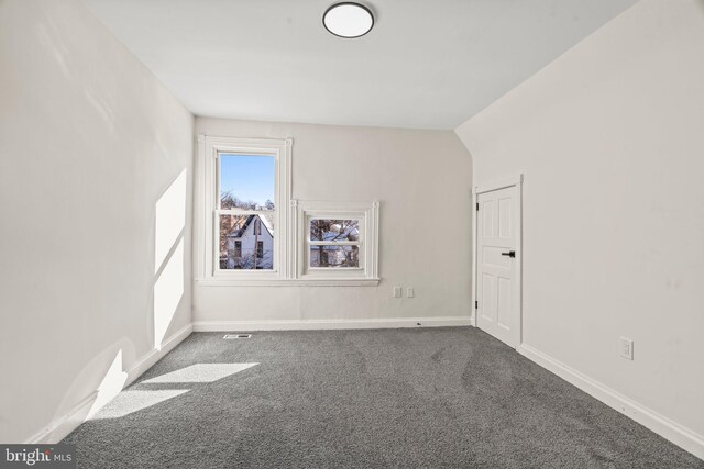 carpeted spare room with visible vents and baseboards