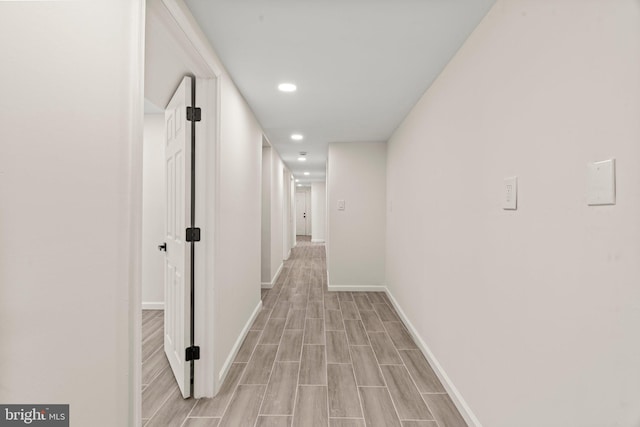 corridor with recessed lighting, light wood-type flooring, and baseboards