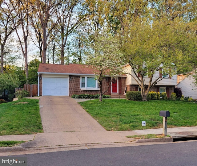 single story home with brick siding, fence, a front yard, and a garage