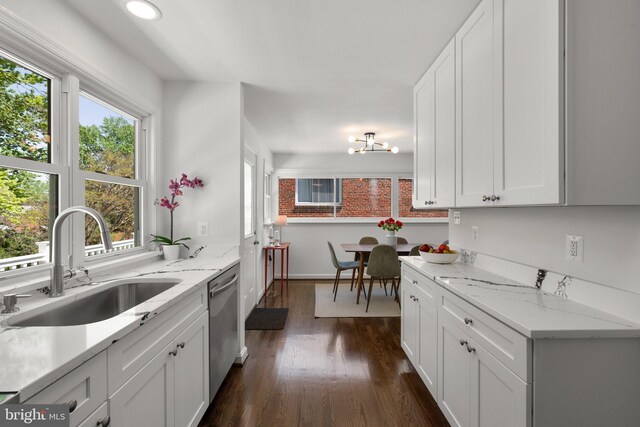 kitchen with white cabinetry, stainless steel dishwasher, a sink, dark wood finished floors, and a notable chandelier