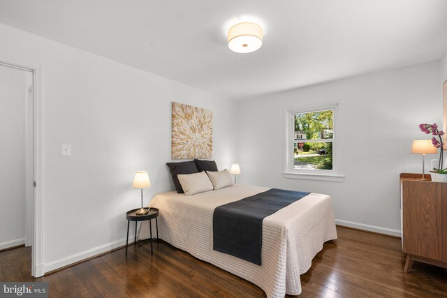 bedroom with wood finished floors and baseboards