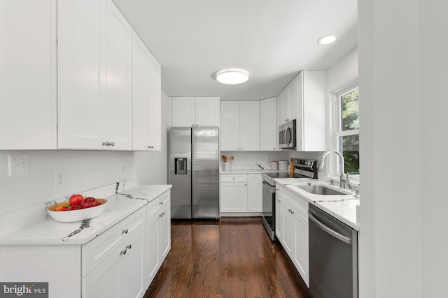kitchen featuring white cabinets, stainless steel appliances, a sink, and dark wood-style flooring