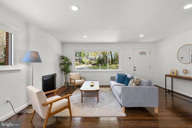 living room featuring wood finished floors, recessed lighting, and a brick fireplace