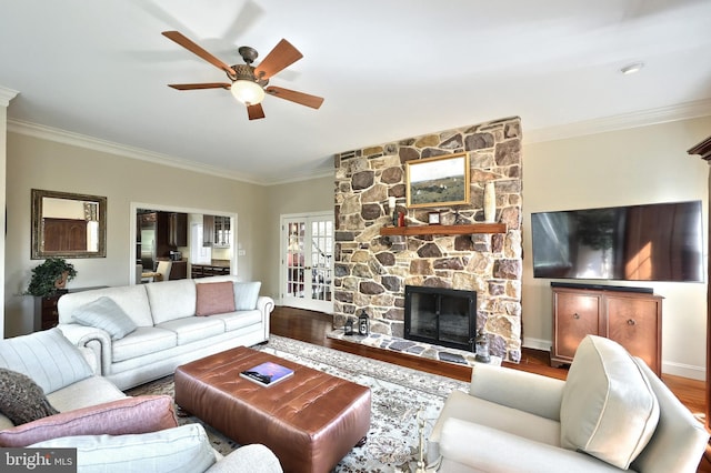 living room with a fireplace, wood finished floors, crown molding, and a ceiling fan
