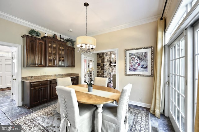 dining space with visible vents, a healthy amount of sunlight, crown molding, and a chandelier